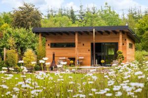 a log cabin in the woods with a field of flowers at Peaceful Bothy Retreat in Nairn