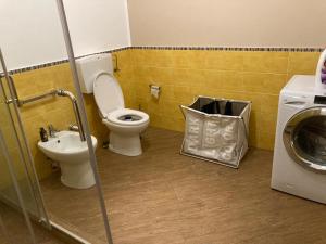 a bathroom with a toilet and a sink and a washing machine at Casa Vacanze Ginevra in Capo dʼOrlando
