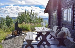 uma mesa de madeira e banco num alpendre de uma cabina em Beautiful Home In Uvdal With 3 Bedrooms And Sauna em Uvdal