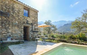 uma casa com piscina, mesa e guarda-sol em Amazing Home In Feliceto With Kitchenette em Feliceto