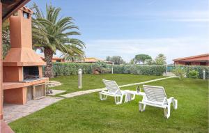two white chairs sitting on the grass in a yard at Trilo Beach in Monte Nai