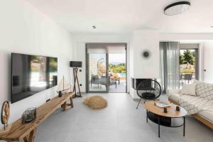 ein Wohnzimmer mit Sofa und Tisch in der Unterkunft Koni Villas Agia Paraskevi by Halkidiki Villas in Agia Paraskevi