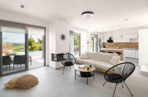 a living room with a couch and a table and chairs at Koni Villas Agia Paraskevi by Halkidiki Villas in Agia Paraskevi