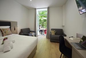 a bedroom with a bed and a desk and a window at Hôtel Continental in Bastia