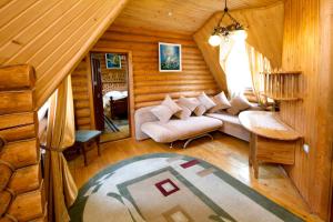 a living room with a couch in a log cabin at Smerekovyi Dvir in Zhdenievo