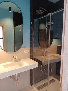een badkamer met een douche, een wastafel en een spiegel bij Apartments Andrea in Jesenice