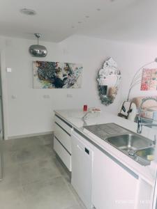 a white kitchen with a sink and a counter at Tus vacaciones en el corazón de Alicante! in Alicante