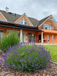 an orange house with purple flowers in front of it at Korall Apartman in Balatonfůzfő