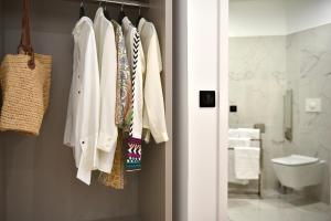 a bathroom with a rack of clothes in a bathroom at Hôtel Continental in Bastia