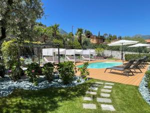 a backyard with a swimming pool with chairs and umbrellas at Charming Bellagio Boutique Hotel in Bellagio