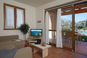 a living room with a couch and a television at Appartamenti Corte Leonardo in Garda
