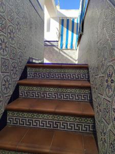 a set of stairs with patterns on the wall at Chalet adosado con azotea andaluza y patio, junto a la playa in Isla Cristina