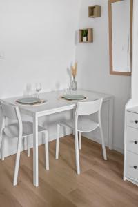 mesa de comedor blanca con sillas blancas y pared blanca en *Lasuite #3 GREEN*, en Valenciennes