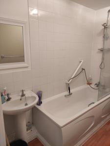 a bathroom with a bath tub and a sink at Immaculate 1-Bed Apartment in Borehamwood in Borehamwood
