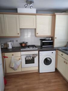 a kitchen with a stove and a washing machine at Immaculate 1-Bed Apartment in Borehamwood in Borehamwood