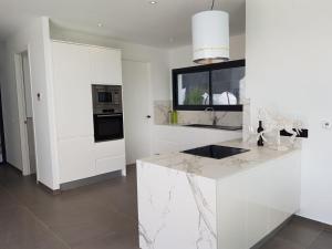 une cuisine avec des armoires blanches et un comptoir en marbre dans l'établissement Villa Sofia, à Jávea