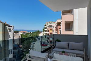 d'un balcon avec un canapé et une vue sur la ville. dans l'établissement Central Makarska - Apartments Šantrić, à Makarska