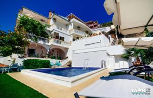 a house with a swimming pool in front of it at Apartments Mar in Ulcinj