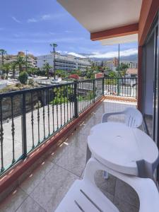 a balcony with a white table and a view of a city at Apartamentos Chinyero in Puerto de la Cruz