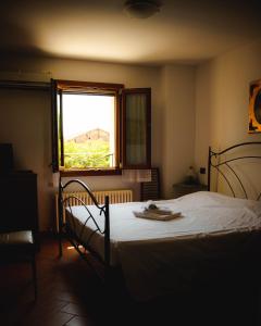 een slaapkamer met een bed en een raam en een raam bij SPIEDO IMPERIALE - Locanda e Ristorante in Cotignola