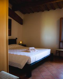 een slaapkamer met een groot bed met witte lakens bij SPIEDO IMPERIALE - Locanda e Ristorante in Cotignola