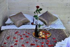 a bed with a table with a vase of flowers on it at Apartament Plus in Mrągowo