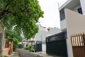 an alley with a black gate on a white building at Super OYO 91074 Stariez Senen Syariah in Jakarta