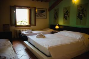 een slaapkamer met 2 bedden en een raam bij SPIEDO IMPERIALE - Locanda e Ristorante in Cotignola