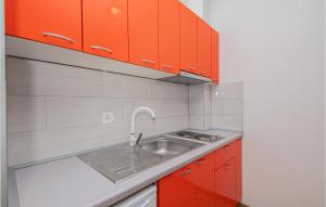 una cocina con armarios rojos y fregadero en Beautiful Apartment In Drvenik With Kitchen en Drvenik