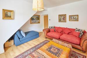 a living room with a red couch and a blue chair at Host & Stay - Elliott Terrace in Wark