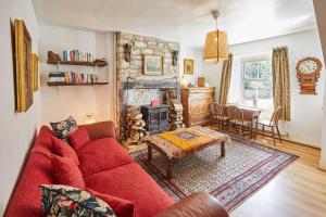 a living room with a red couch and a fireplace at Host & Stay - Elliott Terrace in Wark