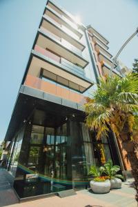 a tall building with palm trees in front of it at Graphic Hotel Batumi in Batumi
