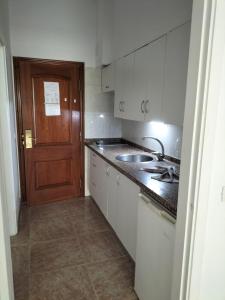 a kitchen with a sink and a wooden door at Apartamentos Chinyero in Puerto de la Cruz