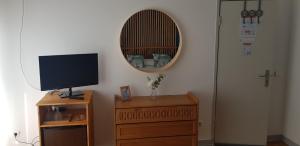 a room with a mirror and a dresser with a television at Casa Maria in Nazaré