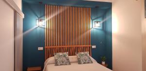 una camera da letto con pareti blu e un letto con due cuscini di Casa Maria a Nazaré