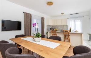 a dining room with a table and a kitchen at 3 Bedroom Stunning Apartment In Kustici in Kustići