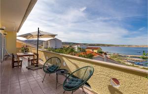 a balcony with chairs and a table and an umbrella at 3 Bedroom Stunning Apartment In Kustici in Kustići