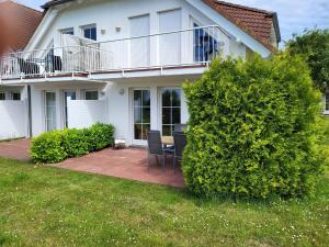 ein Haus mit einer Terrasse mit einem Stuhl im Hof in der Unterkunft Rügen Träume in Sagard