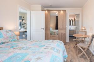 a bedroom with a bed and a table and a desk at Penthouse SeeZeichen mit Seeblick in Nordstrand