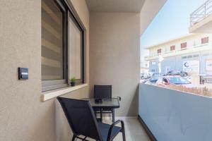 einen kleinen Balkon mit einem Tisch und einem Fenster in der Unterkunft Athena Apartment in Iraklio