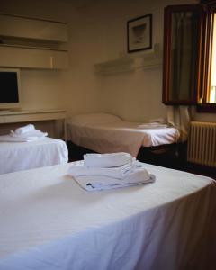 ein Zimmer mit 2 Betten mit weißer Kleidung in der Unterkunft SPIEDO IMPERIALE - Locanda e Ristorante in Cotignola
