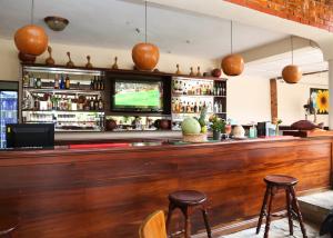 a bar with two stools and a television at Coconut Grove Regency Hotel in Accra