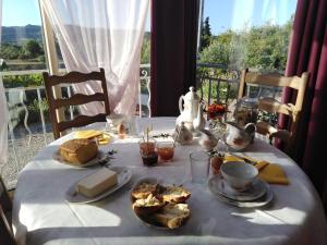 une table avec un tissu de table blanc et de la nourriture dans l'établissement LA GRAND'VIGNE, à Chauzon