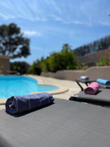 Una toalla está en una mesa junto a la piscina. en Villa Cocody en Bandol