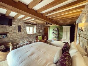 a bedroom with a bed and a stone wall at The Cowshed in Llangollen