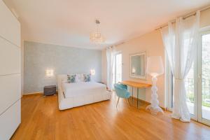 - une chambre avec un lit blanc, une table et une fenêtre dans l'établissement Villa Mastrissa Taormina, à Taormine