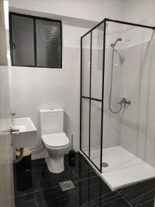 a bathroom with a toilet and a glass shower at Beautifull And Airy Appartment Corfu Town in Kanoni