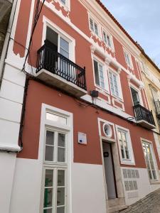 Edificio rojo y blanco con balcón en The Bastion Elvas Apartments, en Elvas