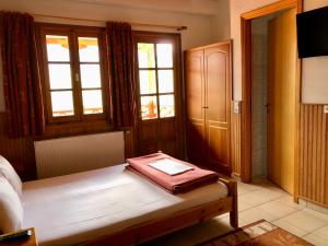 a bedroom with a bench with a box on it at Apostolos Hotel in Metsovo