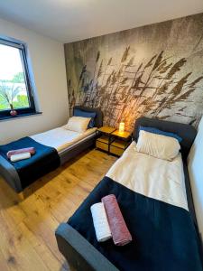 um quarto com duas camas e um sofá em Apartament DELUX ROZTOCZE em Tomaszów Lubelski